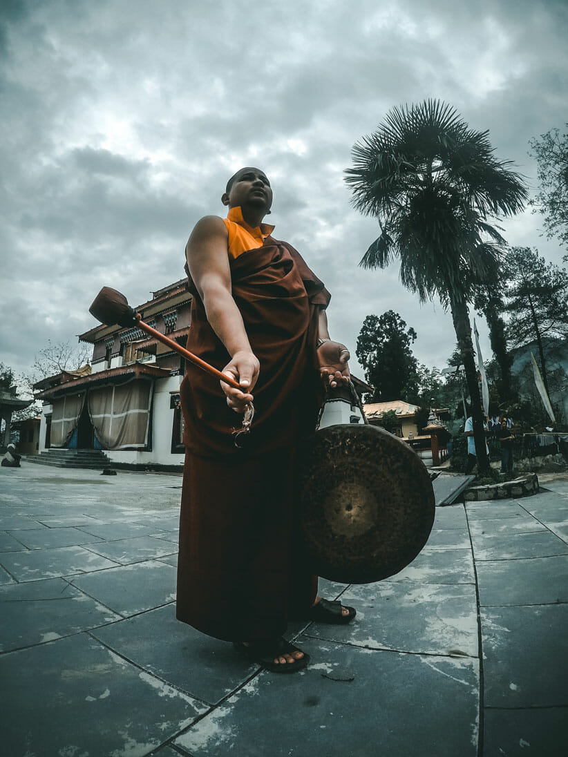 Buddhist monk with drum promoting music for wellness 